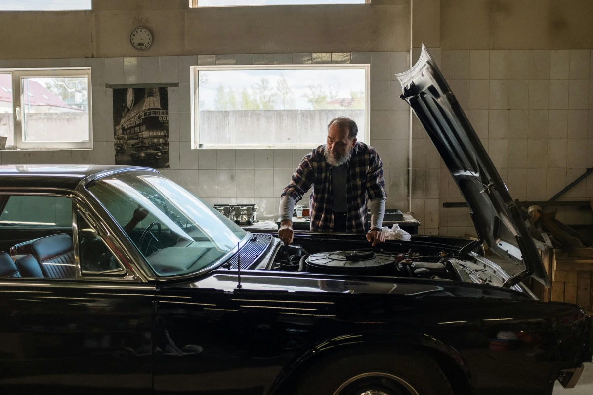 older man working on his car